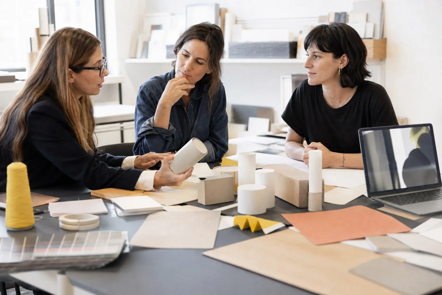 Professioniste discutono materiali creativi durante una consulenza legale
