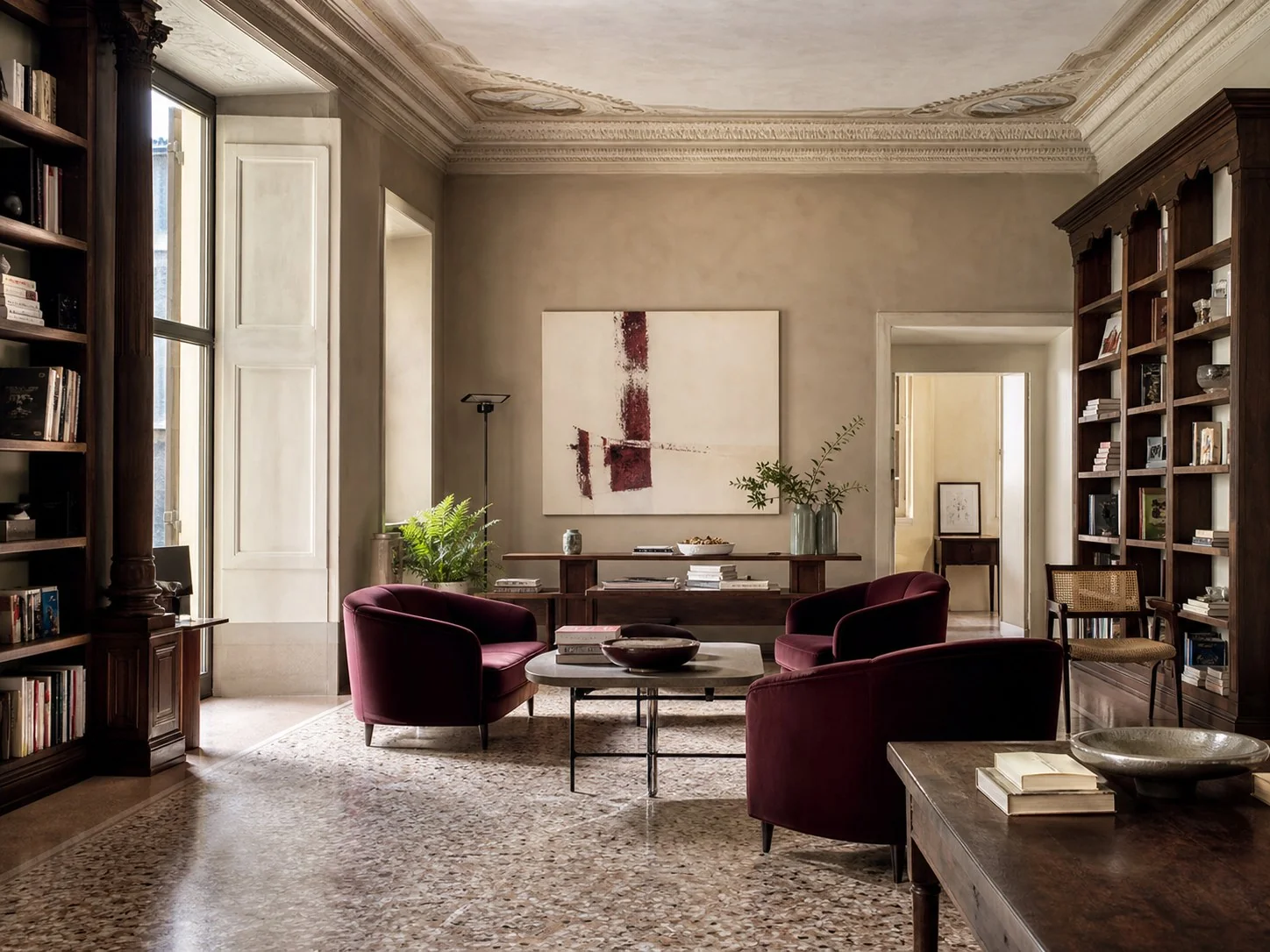 Biblioteca della dimora con poltrone color vino e arte contemporanea