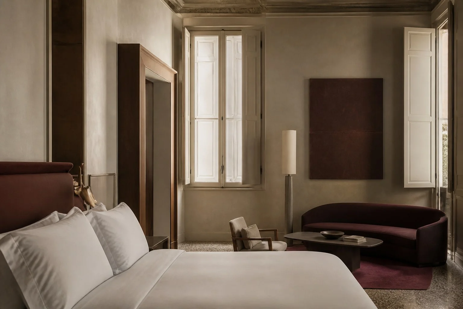 Suite Ardea con letto, salotto color vino e finestre storiche